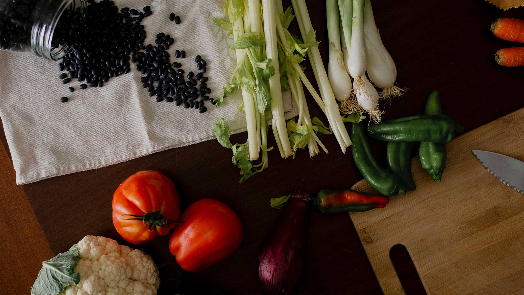 Chopping board with fresh vegetables and beams