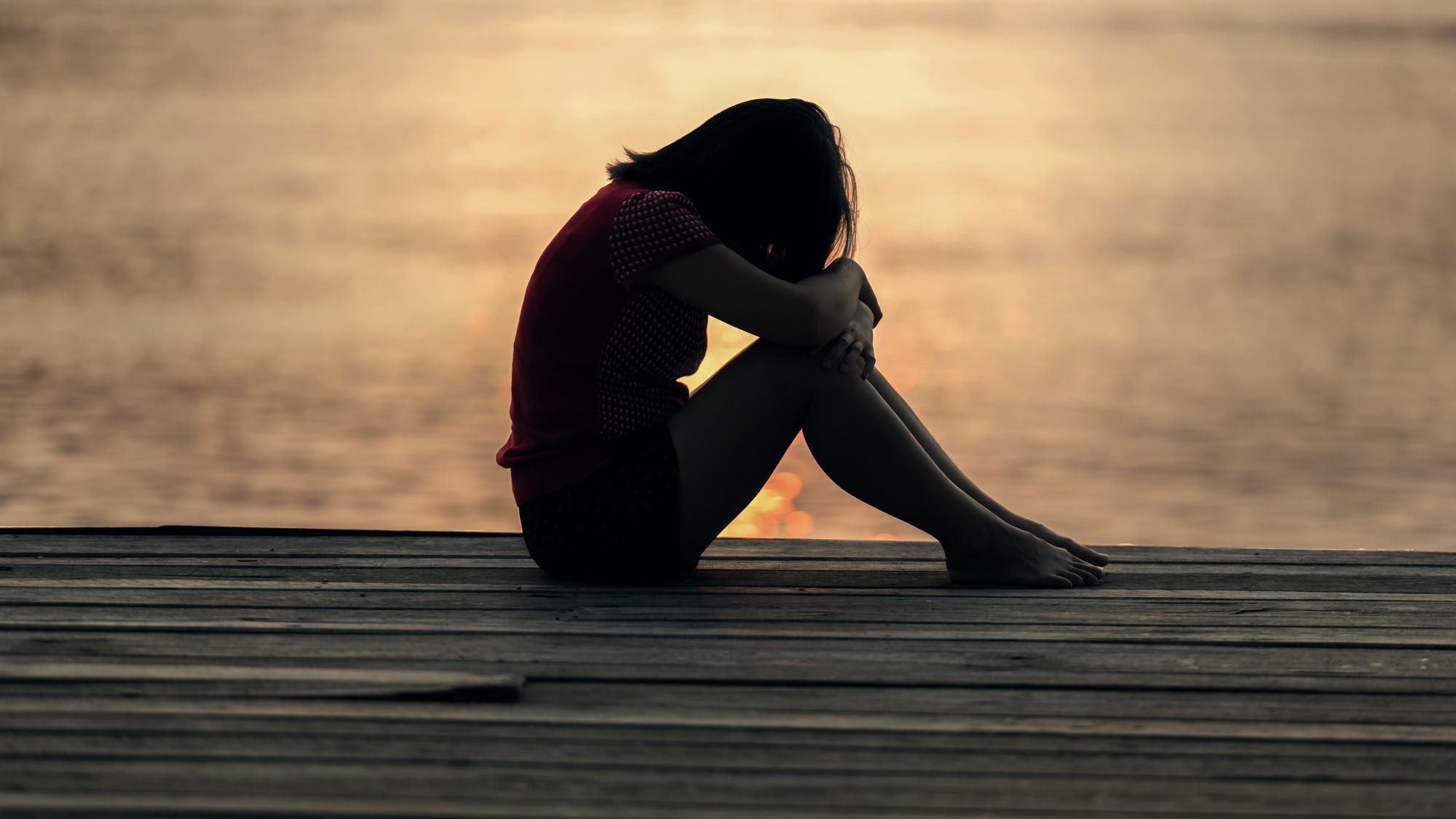 Woman sitting at the water's edge